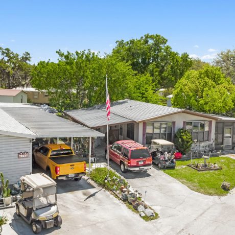 cars and golf carts parked outside of manufactured home rentals